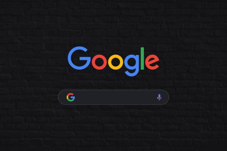 Google logo above a dark-themed search bar with a microphone icon, set against a black brick wall background.